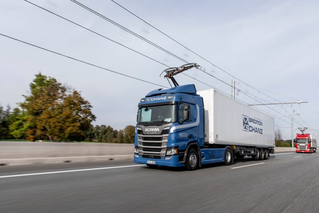 AD Un certo numero di aziende sta lavorando su semi elettrici e camion da trasporto, ma i conducenti dovranno fare i conti con gamme limitate e lunghi tempi di ricarica. Mentre questi problemi riguardano anche i veicoli passeggeri elettrici, sono più problematici quando si tratta di trasportare merci. Tuttavia, la soluzione potrebbe venire guardando al passato. In particolare, Continental Engineering Services e Siemens Mobility stanno collaborando per sviluppare e produrre "collettori di corrente" conosciuti come pantografi. Più comunemente associati a treni e tram elettrici, i pantografi sono montati sulla parte superiore del veicolo e ricevono elettricità dalle linee aeree. Leggi anche: Il Regno Unito approva lo schema E-Highway, installa fili aerei sull'autostrada per caricare i camion Le due aziende prevedono di avere un cablaggio sopraelevato installato su "tratti di autostrada molto frequentati". I camion e i semirimorchi dovrebbero semplicemente guidare sotto di loro e i cavi alimenterebbero i loro motori elettrici mentre ricaricano le loro batterie allo stesso tempo. Vale anche la pena menzionare che il sistema è previsto per funzionare non solo con veicoli elettrici, ma anche con camion con celle a combustibile e propulsori ibridi. La tecnologia eHighway di Siemens Mobility è attualmente in fase di test in tre diversi siti in Germania e il ministero federale dei trasporti stima che solo 2.485 miglia (4.000 km) della rete del paese lunga 8.078 miglia (13.000 km) avrebbe bisogno di essere equipaggiata con cablaggio aereo. Questo perché circa due terzi del consumo di carburante del traffico di camion a lunga distanza si verifica su meno di un terzo della rete stradale. Mentre la tecnologia si è già dimostrata, le aziende hanno notato che c'è ancora del lavoro da fare in quanto hanno bisogno di sviluppare collettori attuali che possono essere offerti ai produttori di veicoli commerciali in modo conveniente e in volumi significativi. Questa è una ragione chiave per la partnership e, se ha successo, i sistemi di linee aeree potrebbero alla fine spuntare in tutta Europa. Secondo l'amministratore delegato di Continental Engineering Services, Christoph Falk-Gierlinger, "stiamo trasferendo il principio dell'elettrificazione ferroviaria alla strada". Ha aggiunto che "i collettori attuali saranno sviluppati e prodotti in conformità con gli standard automobilistici", e ha notato che la partnership è un "passo importante verso un trasporto merci neutrale per il clima".